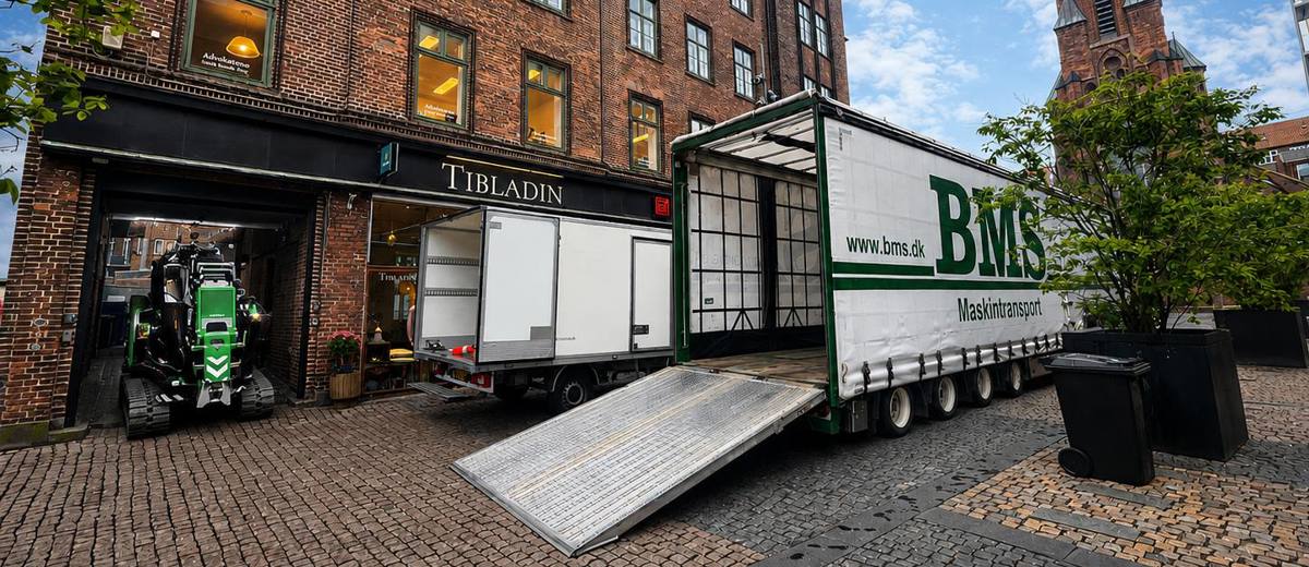 Minikran transporteres gennem en smal port til baggård i Aarhus.