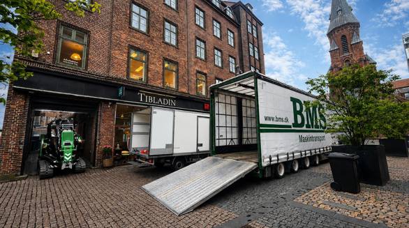 Minikran transporteres gennem en smal port til baggård i Aarhus.