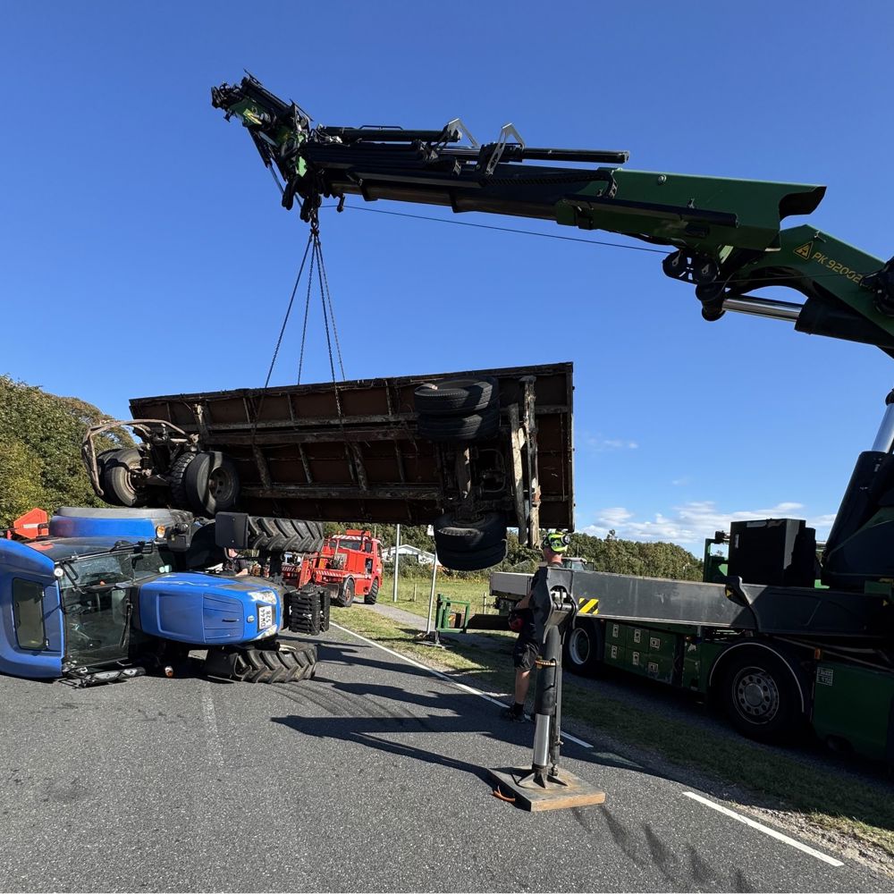 Lastbilkran bjærger en væltet traktor efter et trafikuheld