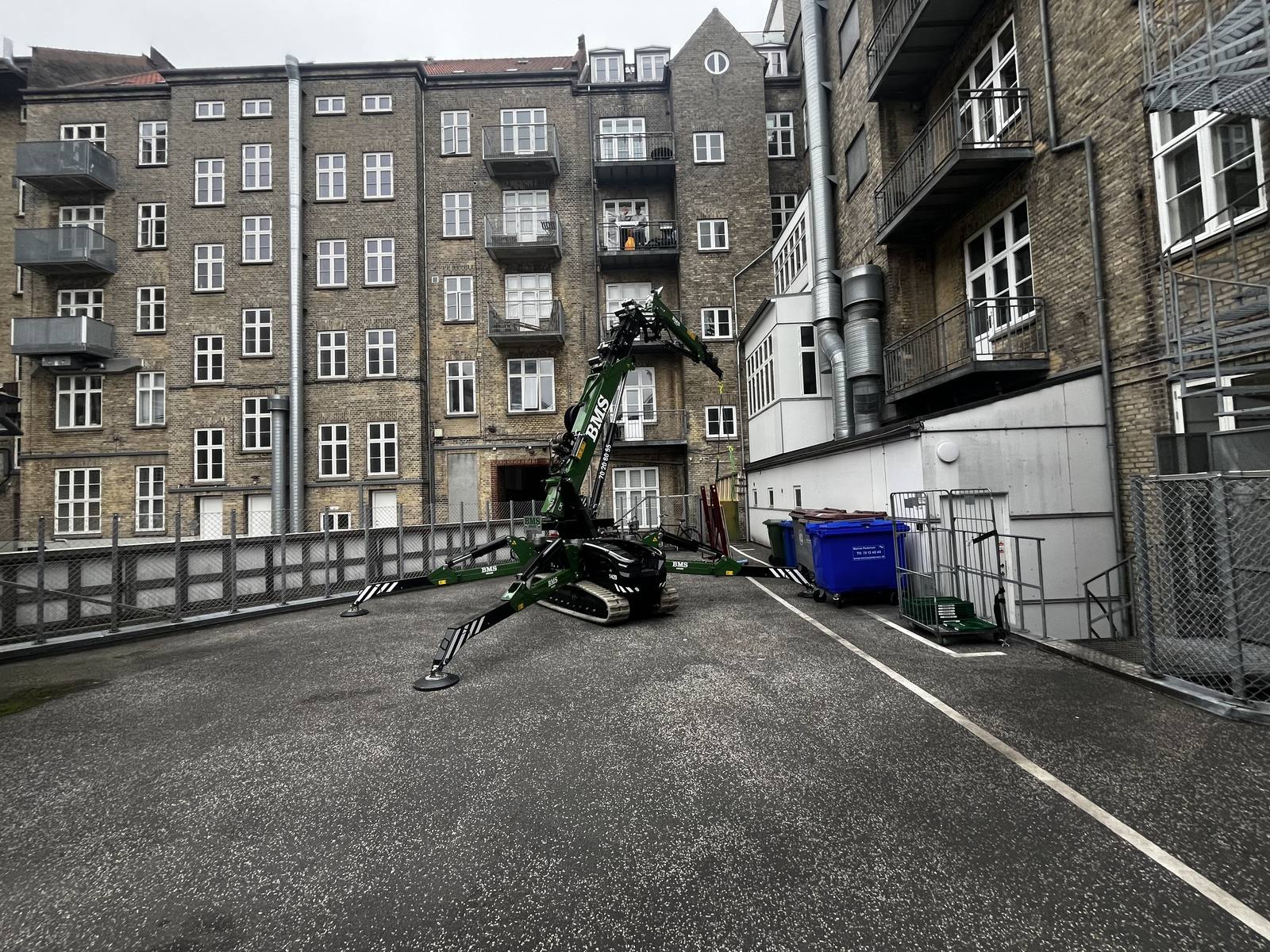 Minikran udfører løfteopgave i baggård i Aarhus.