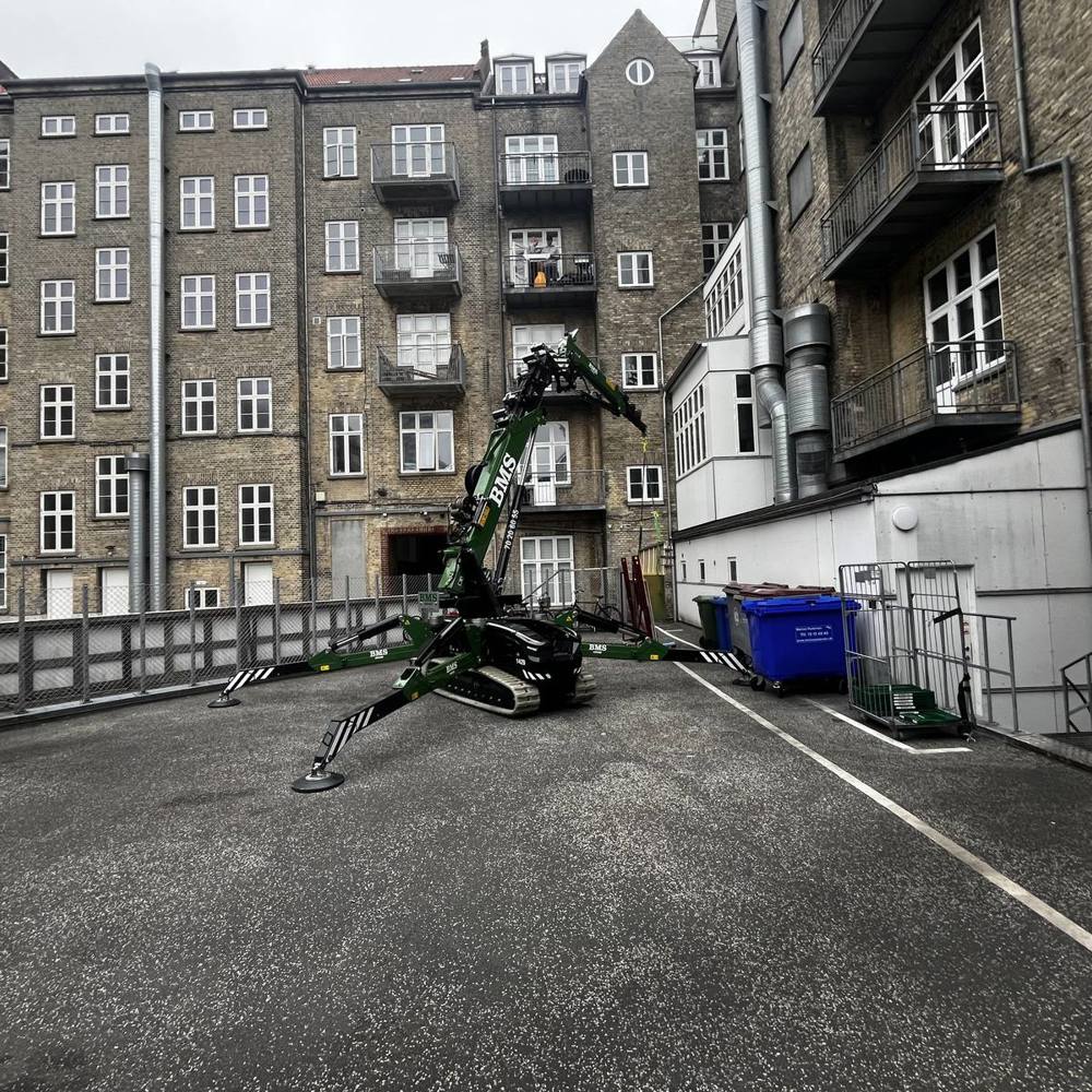 Minikran udfører løfteopgave i baggård i Aarhus.