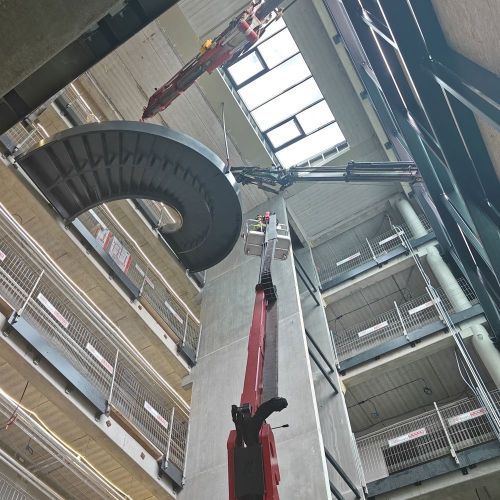Spindeltrappe hejses op gennem åbning i facade med mobilkran