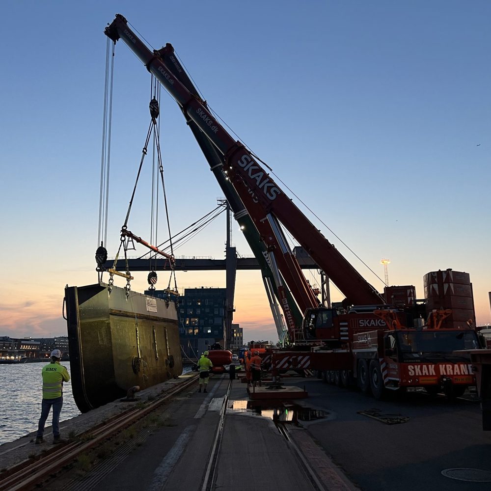 Kran løfter historisk dokport ved kaj i København
