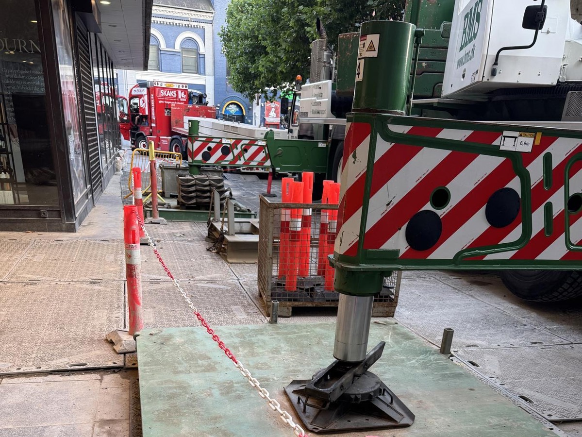 Mobilkranens støtteben placeret på understøtning i det afspærrede arbejdsområde.