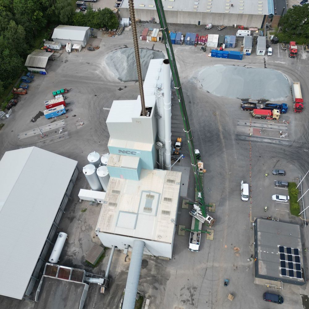 Luftfoto af kran ved industribygning med siloer