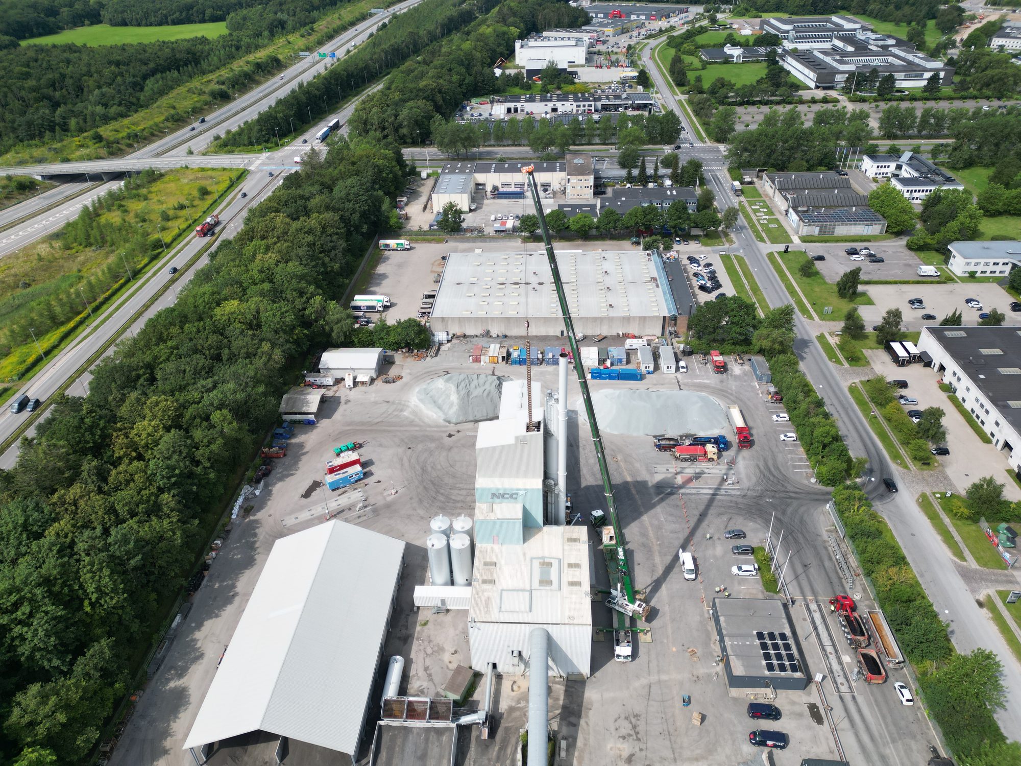 Luftfoto af en BMS-kran der arbejder i stor højde ved et industrianlæg