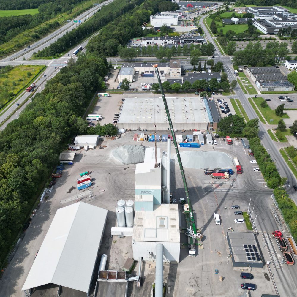 Luftfoto af en BMS-kran der arbejder i stor højde ved et industrianlæg
