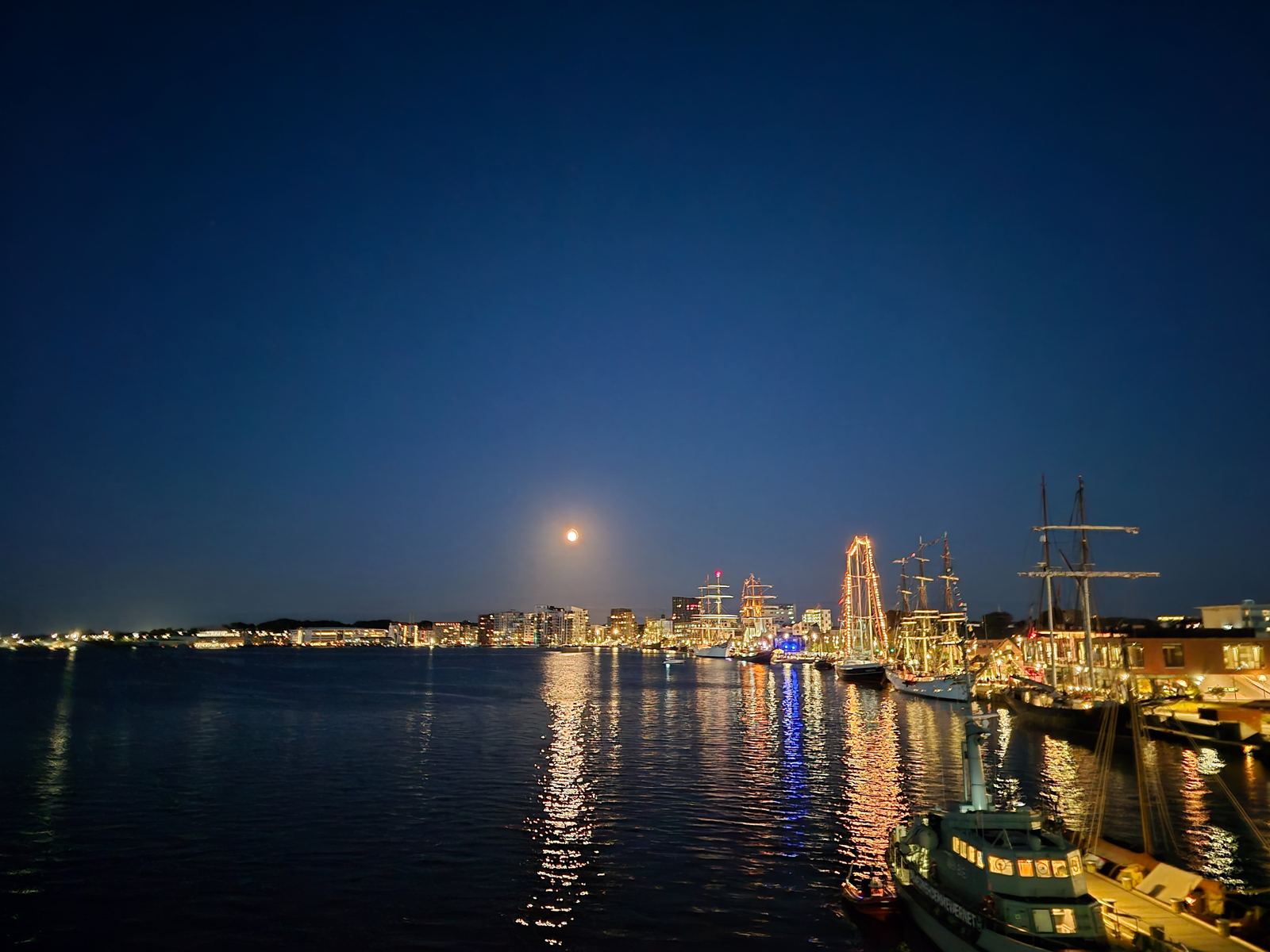 Månen over havnen i Aalborg med oplyste sejlskibe