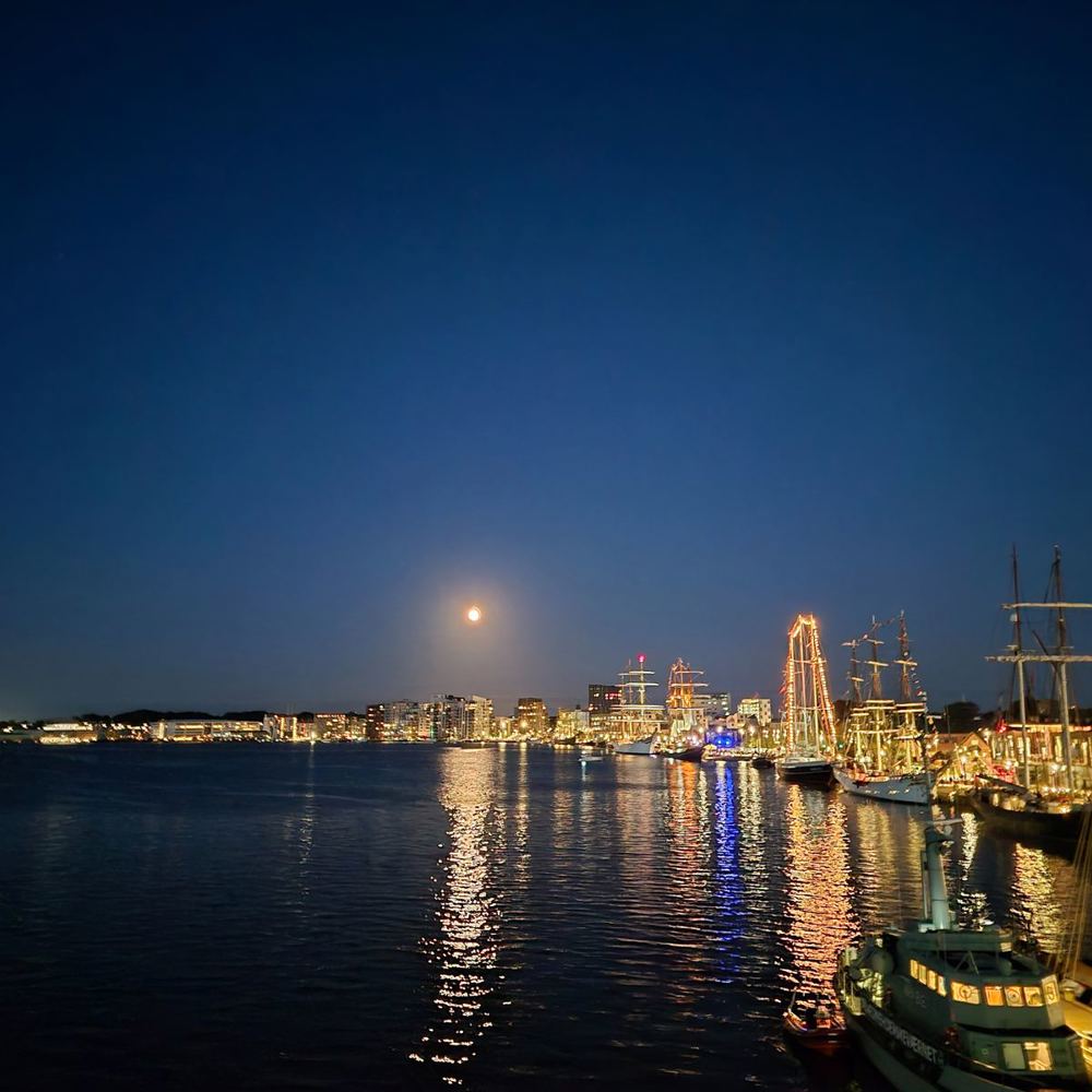 Månen over havnen i Aalborg med oplyste sejlskibe