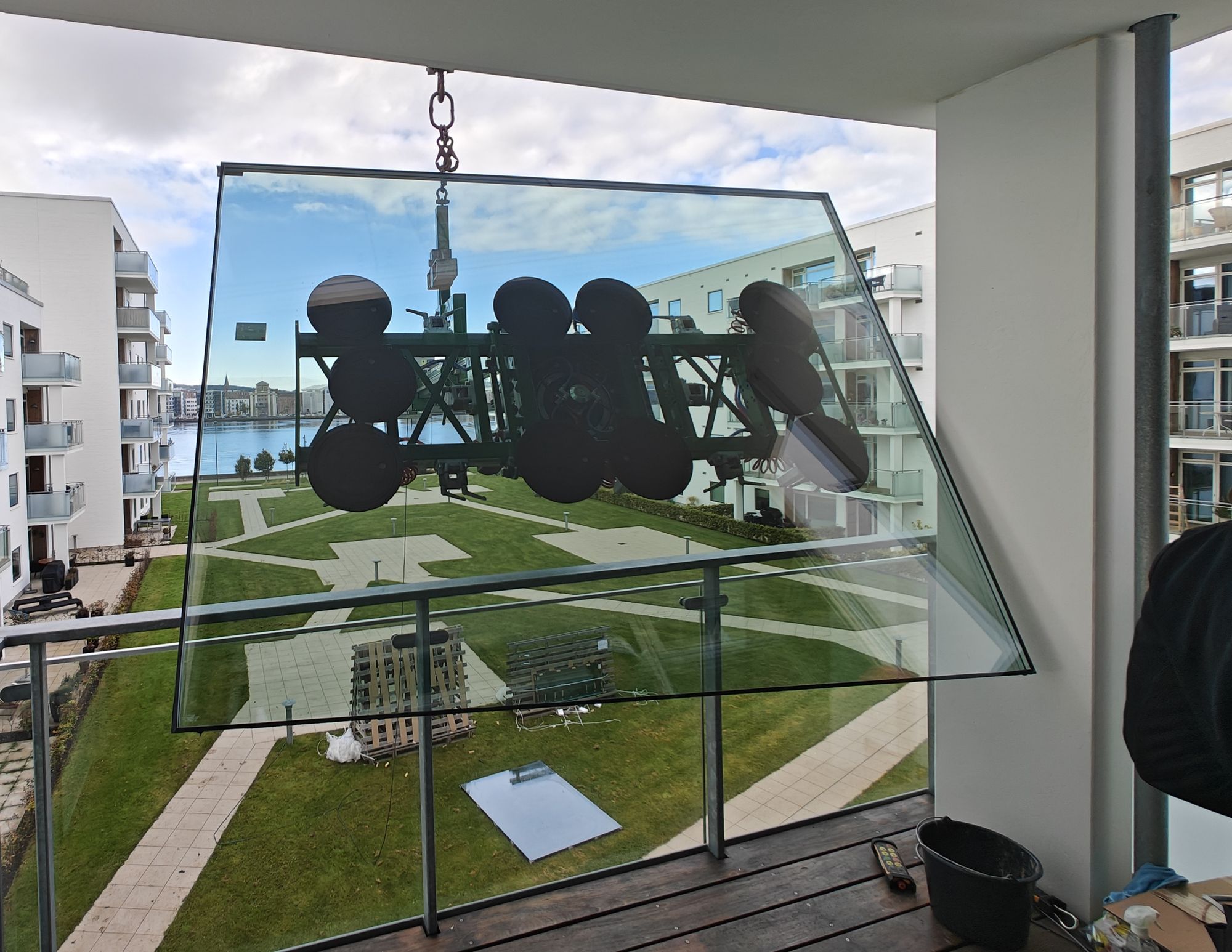 Glasmanipulator holder stort glaselement på plads ved altan