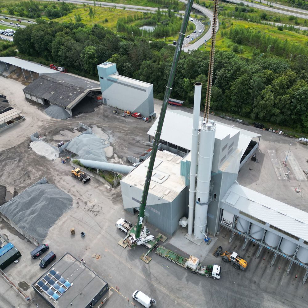 Luftfoto af mobilkran ved industrianlæg i solopgang