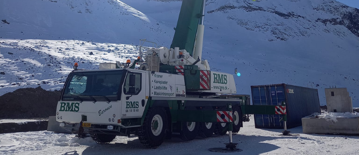 BMS mobilkran i sneen i Grønland med sol bagved