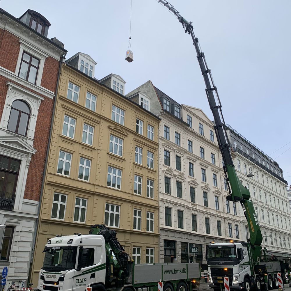 Lastbilkran hejser udstyr op over ejendomme i det centrale København