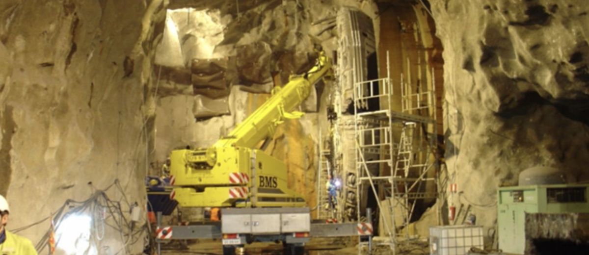 Mobilkran arbejder i tunnel under udskiftning af borskærehoved på boremaskine