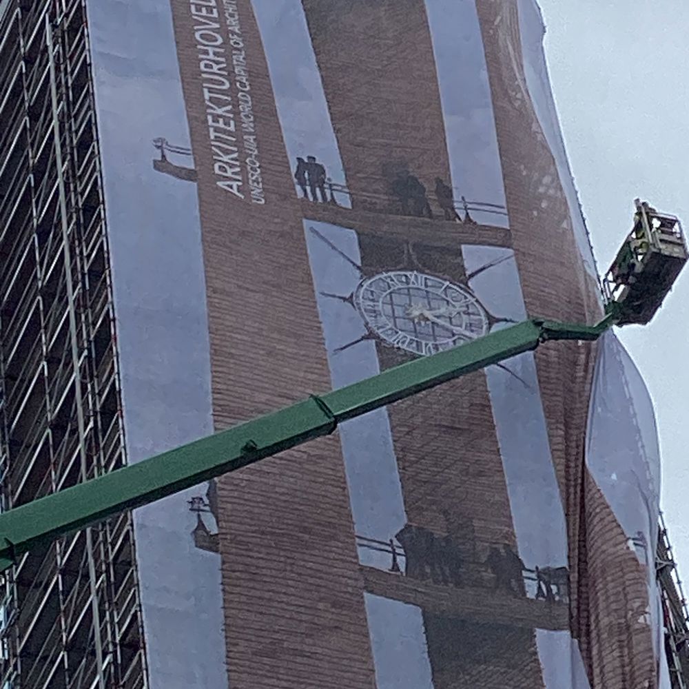 Banner med teksten "Arkitekturhovedstad 2023" monteres på Københavns Rådhustårn